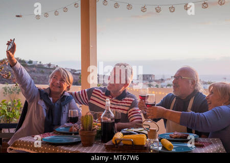 Gruppe der Erwachsenen Freunde ältere Menschen im Ruhestand Spaß ein Bild wie selfie alle zusammen bei einem Abendessen im Freien auf der Terrasse Dachterrasse feiern. Stockfoto