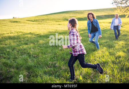 Ein kleines Mädchen mit ihrem älteren Großeltern spielen im Freien in der Natur. Stockfoto