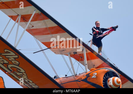 Fliegender Circus Wingwalker Kirsten. Mädchen auf dem Flügel, Flügel gehen, Flügelspazierer, Flügelspaziergang. Fliegen im blauen Himmel. Boeing Stearman Doppeldecker Stockfoto