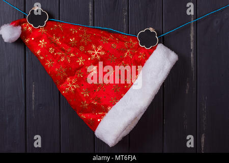 Santa Claus caps hängen an einem Seil, eine Inschrift Weihnachten Stockfoto