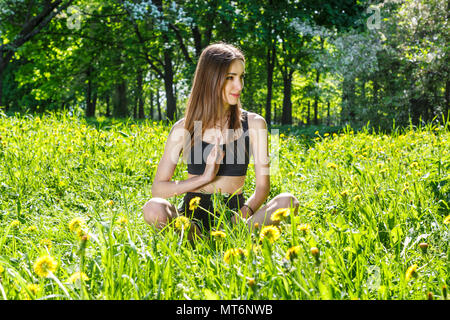 Junge, schöne Frau Sport Übungen in eine sonnige Wiese im Park Stockfoto