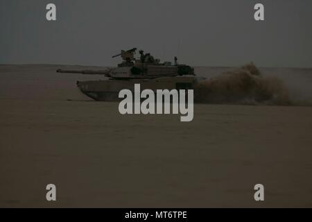 Eine M1A2 Abrams Kampfpanzer zu Alpha Company, 1.Bataillon, 12 Cavalry Regiment, 3. gepanzerte Brigade Combat Team, 1.Kavallerie Division Manöver durch die Udairi Bereich Komplex wie ein Teil von einem Angriff auf die gegnerischen Kräfte während Situationstraining übung des Unternehmens am 15. Juli 2017 zugewiesen. Die STX wurde verwendet, um die Einheit durch die Mission wesentliche Aufgaben zur Validierung der Bereitschaft der kombinierten Waffen Bataillone zu unterstützen. (U.S. Armee Foto: Staff Sgt. Leah R. Kilpatrick) Stockfoto