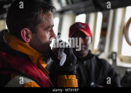 171001-N-RP 878-064 Faslane, Schottland (Okt. 2010) 1, 2017) eine Schottische pilot Kapitän kommuniziert mit einem Tug Boat an Bord der Arleigh-Burke-Klasse geführte Anti-raketen-Zerstörer USS Donald Cook (DDG75) als das Schiff fährt Faslane, Schottland, in der Übung gewaltige Schild 2017, Okt. 1 zu beteiligen. Dieses Schild ist in den USA eine 6. Flotte-led, Naval auffällig und Unterstützung der Kräfte der NATO-Übung durchgeführt, die Verbesserung der Interoperabilität der Alliierten in einem live-fire integrierte Luft- und Raketenabwehr Umwelt, den Einsatz der NATO Command und Control reporting Strukturen. (U.S. Marine Foto von Massenkommunikation Spezialist Stockfoto