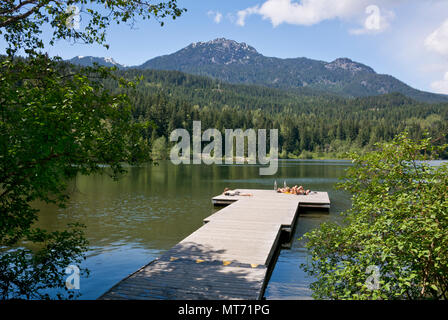 Menschen beim Sonnenbaden auf einem Pier auf Nita Lake in Whistler, BC, Kanada Stockfoto