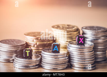 Steuerkonzept mit Alphabet Block auf einem gold gestapelt der Münzen. Stockfoto