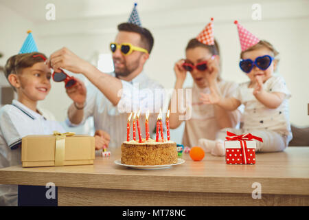 Geburtstag Kuchen mit Kerzen und Familie. Stockfoto