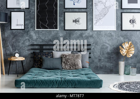 Blattgold in der Nähe von Green Matratze mit Kissen in modernes Schlafzimmer Innenraum mit Galerie der Poster Stockfoto