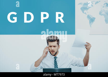 Wütend Geschäftsmann am Telefon zu sprechen, an seinem Schreibtisch mit einem bipr Banner über seinem Kopf sitzen. Stockfoto