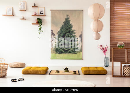 Japanische Esszimmer Interieur mit einem Baum Poster, Lampe, Kissen und Tatami Matten mit Topf und Tassen auf dem Boden Stockfoto