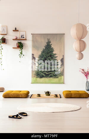 Vorderansicht des flip-flops in einer asiatischen Esszimmer Interieur mit einem Baum Grafik an der Wand, Futons und Kronleuchter Stockfoto
