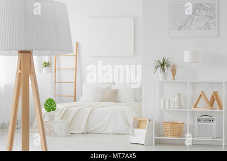 Leere mockup Poster an der Wand hängen über Kingsize-Bett in Weiß Schlafzimmer Innenraum mit Holz eingerichtet Stockfoto