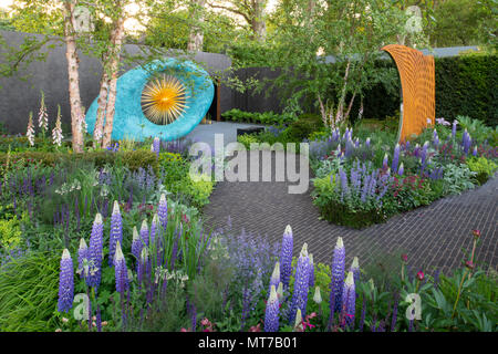 Skulpturen umgeben von Pflanzen einschließlich Campanula glomerata 'West Country Persian Slipper" im David Harber und Savills Garten entworfen von Nic Howard zu der Stockfoto