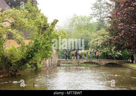 Die Menschen genießen die May Bank Holiday in Bourton auf dem Wasser, Gloucestershire, UK innerhalb der Cotswolds Gebiet von außergewöhnlicher natürlicher Schönheit Stockfoto