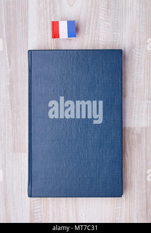 Flach blau texturiert Notepad mit der Französischen Flagge auf zahnstocher als Lesezeichen. Stockfoto