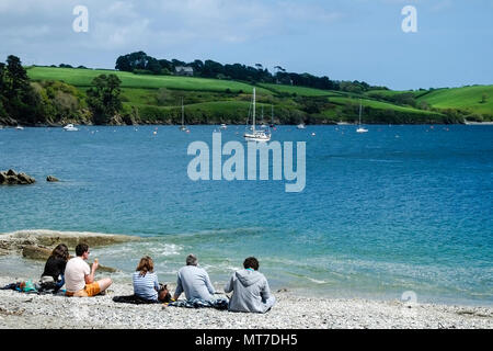 Urlauber entspannen auf dem privaten Strand Polgwidden Cove at Trebah Garten in Cornwall. Stockfoto