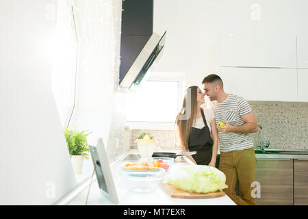 Schöner Mann küssen Frau Kochen in der Küche Stockfoto