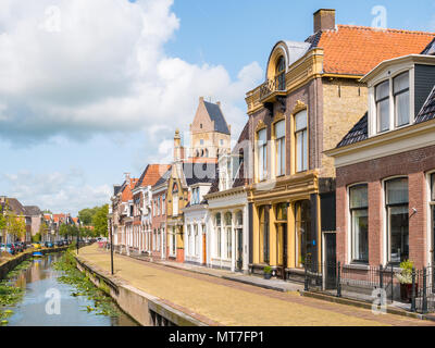 Street Scene der Kleinen Dijlakker Kanal und Turm der evangelischen Kirche in der Altstadt von Bolsward, Friesland, Niederlande Stockfoto
