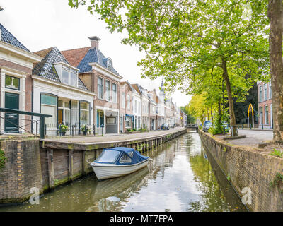 Kanal mit Bäumen, Boot und historischen Häuser in der Altstadt von Bolsward, Friesland, Niederlande Stockfoto