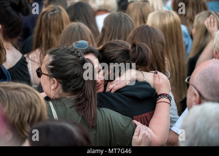 Zwei Mädchen schreien und Hug während des Manchester zusammen Chor Konzert im Gedenken an die Opfer der Arena Bombenattentat in Manchester, Großbritannien, am 22. Mai 2018. Prinz William und der britische Premierminister Theresa May zusammen mit anderen Politikern, sowie Angehörige der Getöteten, und Rettungskräfte zur Szene des Terror Angriff, während Tausende von Menschen in Manchester Dienstag versammelten sich am ersten Jahrestag des Terrorangriffs in der Stadt die 22 Toten. Stockfoto