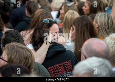 Zwei Mädchen schreien und Hug während des Manchester zusammen Chor Konzert im Gedenken an die Opfer der Arena Bombenattentat in Manchester, Großbritannien, am 22. Mai 2018. Prinz William und der britische Premierminister Theresa May zusammen mit anderen Politikern, sowie Angehörige der Getöteten, und Rettungskräfte zur Szene des Terror Angriff, während Tausende von Menschen in Manchester Dienstag versammelten sich am ersten Jahrestag des Terrorangriffs in der Stadt die 22 Toten. Stockfoto