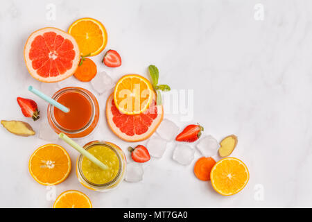 Bunte Säfte oder Smoothies in Gläsern. Ansicht von oben, auf weißem Hintergrund. Stockfoto