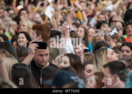 Die Menschen halten die Hände während des Manchester zusammen Chor Konzert im Gedenken an die Opfer der Arena Bombenattentat in Manchester, Großbritannien, am 22. Mai 2018. Prinz William und der britische Premierminister Theresa May zusammen mit anderen Politikern, sowie Angehörige der Getöteten, und Rettungskräfte zur Szene des Terror Angriff, während Tausende von Menschen in Manchester Dienstag versammelten sich am ersten Jahrestag des Terrorangriffs in der Stadt die 22 Toten. Stockfoto