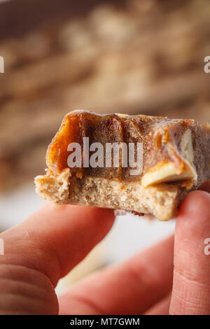 Vegan raw hausgemachte Mutter Candy Bar in der Hand. Gesunder Lebensstil und raw Vegan essen Konzept Stockfoto