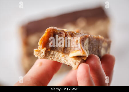 Vegan raw hausgemachte Mutter Candy Bar in der Hand. Gesunder Lebensstil und raw Vegan essen Konzept Stockfoto