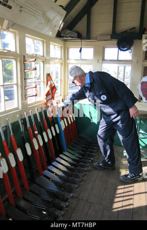 Ein freiwilliger betreibt die Hebel im Stellwerk in New Romney Station; ein Signalgeber Tag auf der Romney, Hythe & Dymchurch Steam Railway, Kent Stockfoto