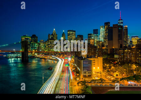 Blick auf den FDR Drive und der Lower Manhattan Skyline bei Nacht, von der Manhattan Bridge Walkway, New York. Stockfoto