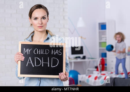 Mutter mit Kind mit ADHD kleine Tafel mit Text Stockfoto