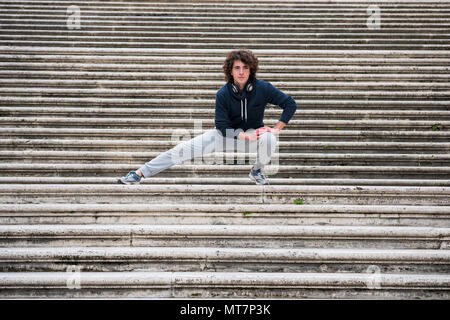 Hübscher junger Sportler dehnen und Aufwärmen für das Training auf Treppe Stockfoto