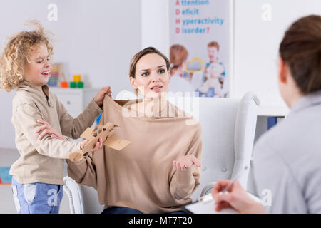 Kind Schwierigkeiten mit der Steuerung von Verhalten, besorgte Mutter und Psychologe Stockfoto