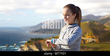 Frau mit Fitness tracker Training über Big Sur Stockfoto