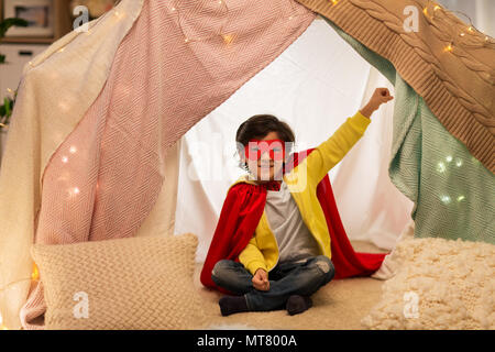 Happy Boy in super hero Material in Kinder Zelt zu Hause Stockfoto