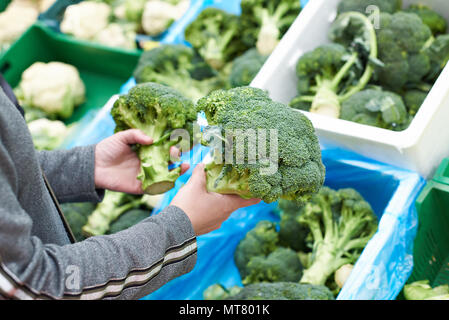 Frau kauft Brokkoli in einem Lebensmittelgeschäft Stockfoto