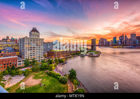 New York, New York, USA Skyline von Manhattan über den East River und die Brooklyn Bridge nach Sonnenuntergang. Stockfoto