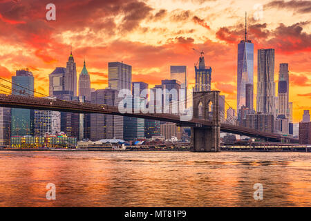 New York, New York, USA Skyline von Manhattan auf den East River und die Brooklyn Bridge nach Sonnenuntergang.