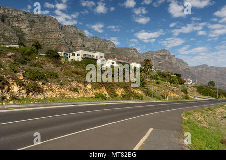 Hauptstraße in Camps Bay Strand mit blauem Himmel und flauschige weiße Wolken über gute Asphaltstraße, Kapstadt, Südafrika Stockfoto