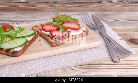 Sandwiches mit Frischkäse, Rettich, frische Gurke, Erdbeeren und Rucola. Banner Stockfoto