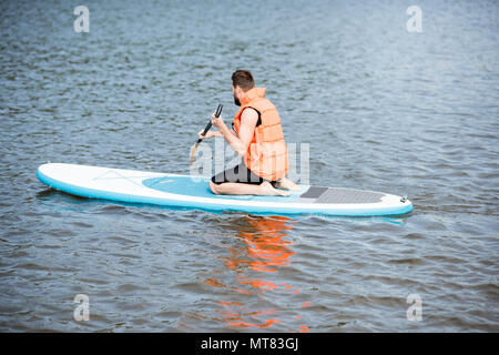 Mann Schwimmen auf dem paddleboard Stockfoto