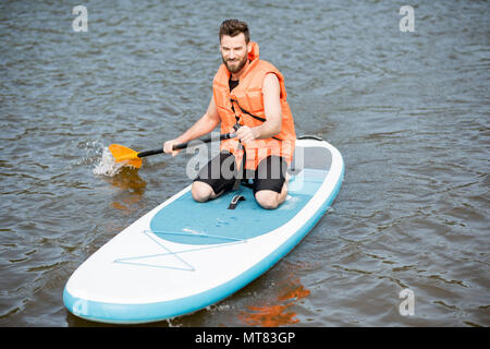 Mann Schwimmen auf dem paddleboard Stockfoto