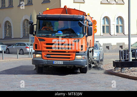 Orange Scania P340 Kehrmaschine reinigt Ort Straße unter Verkehr an einem sonnigen Frühlingstag in Helsinki, Finnland - 24. Mai 2018. Stockfoto