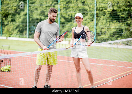 Ein junges Paar, das Spaß auf dem Tennisplatz Stockfoto
