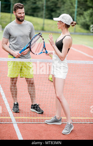 Ein junges Paar, das Spaß auf dem Tennisplatz Stockfoto