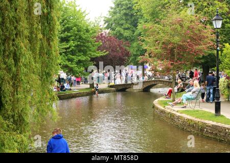 Die Menschen genießen die May Bank Holiday in Bourton auf dem Wasser, Gloucestershire, UK innerhalb der Cotswolds Gebiet von außergewöhnlicher natürlicher Schönheit Stockfoto