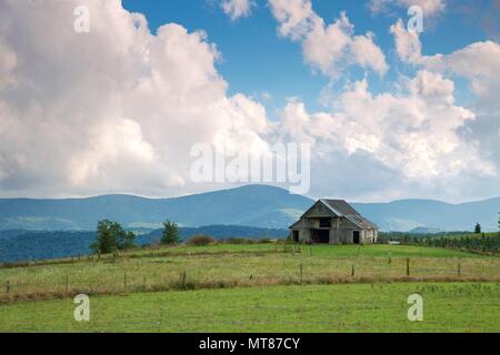 Blue Ridge Mountains, bilden den Hintergrund für dieses kultige Szene einer alten Scheune auf dem Blue Ridge Parkway Stockfoto