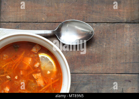 Eine Platte mit würzigen Suppe mit Gemüse und Fleisch auf hölzernen Tisch Stockfoto