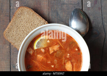 Eine Platte mit würzigen Suppe mit Gemüse und Fleisch auf hölzernen Tisch Stockfoto