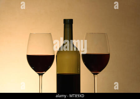 Zwei Weingläser in der Nähe der Flasche Rotwein auf grauem Hintergrund Stockfoto